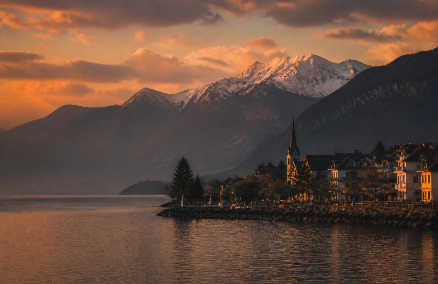 Rives d'un lac alpin au coucher du soleil avec les montagnes en arrière-plan